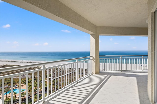 balcony with a water view and a beach view