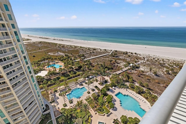 birds eye view of property with a water view and a beach view