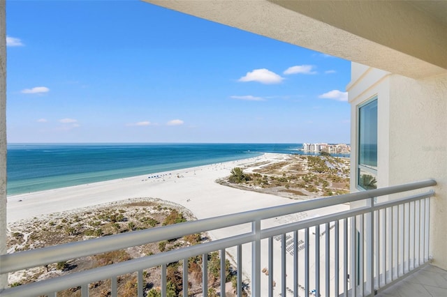 balcony with a water view and a view of the beach