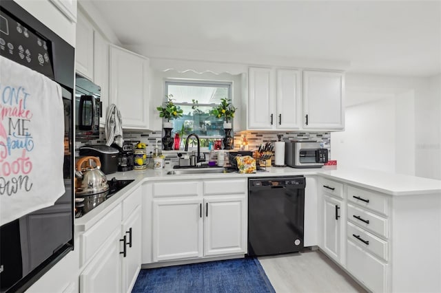 2419 Palmwood Dr, Holiday, FL 34690 - kitchen featuring sink, black appliances, kitchen peninsula, and white cabinets