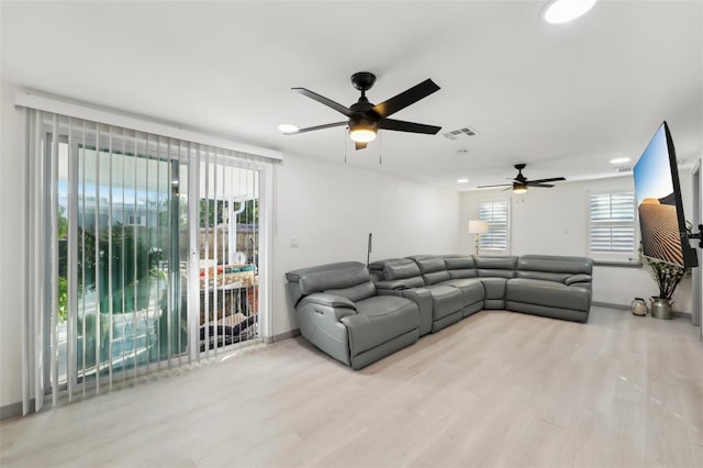 2419 Palmwood Dr, Holiday, FL 34690 - living room featuring ceiling fan, a healthy amount of sunlight, and light hardwood / wood-style floors