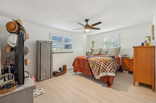 2419 Palmwood Dr, Holiday, FL 34690 - bedroom with multiple windows, ceiling fan, and light wood-type flooring