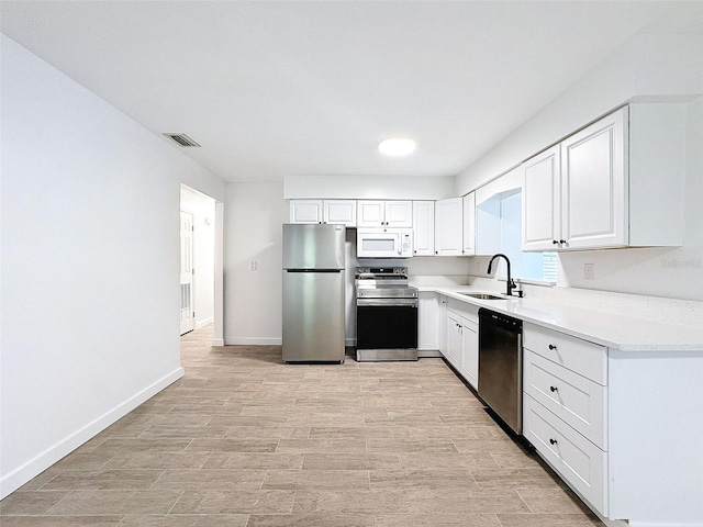 kitchen featuring white cabinetry, appliances with stainless steel finishes, sink, and light hardwood / wood-style floors