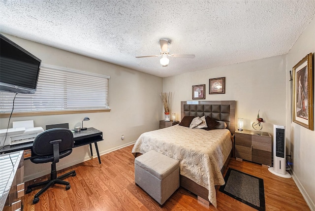 6308 Newtown Cir Unit 8C5, Tampa, FL 33615 - bedroom with baseboards, a textured ceiling, wood finished floors, and a ceiling fan