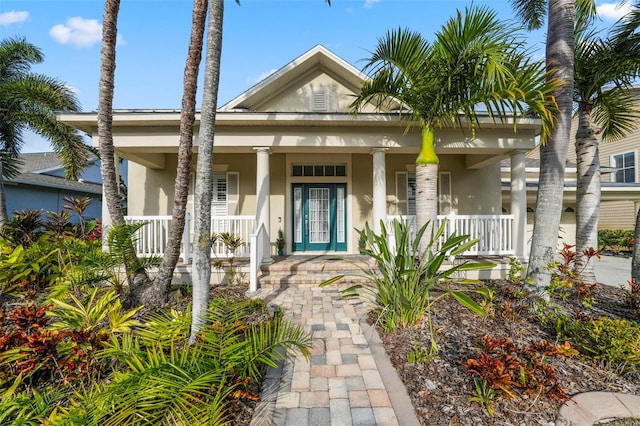 greek revival inspired property featuring stucco siding and covered porch