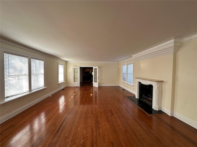 unfurnished living room with ornamental molding, wood finished floors, and a premium fireplace