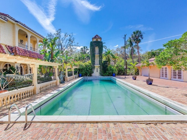 outdoor pool featuring a patio area and french doors