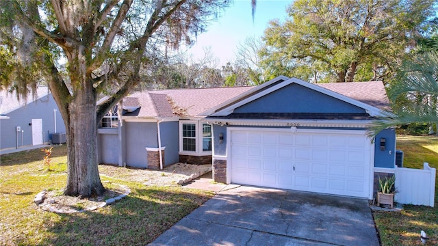 ranch-style home with a garage, central AC, and a front lawn