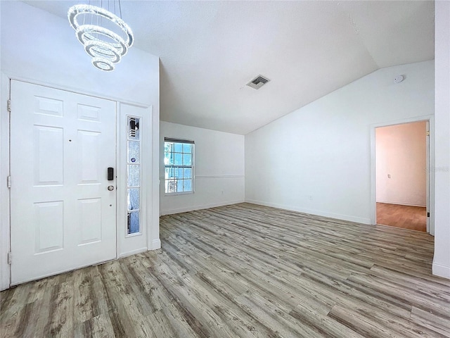 8600 Berkley Dr, Hudson, FL 34667 - foyer entrance with lofted ceiling, a notable chandelier, and light hardwood / wood-style flooring