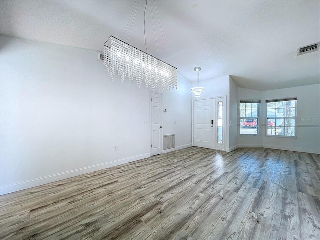 8600 Berkley Dr, Hudson, FL 34667 - interior space featuring a notable chandelier, a textured ceiling, and light hardwood / wood-style flooring