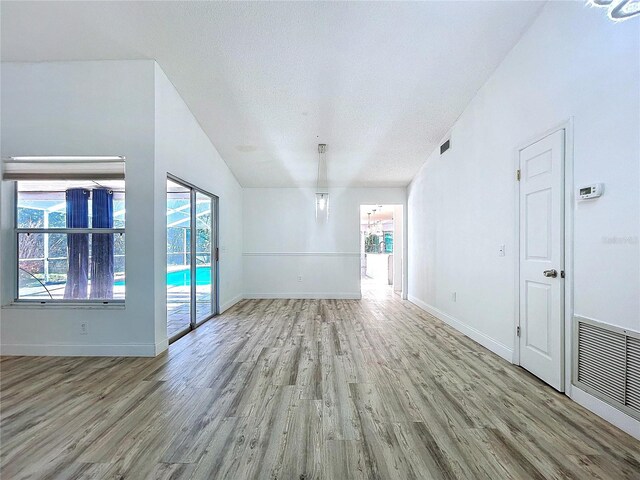 8600 Berkley Dr, Hudson, FL 34667 - spare room featuring plenty of natural light, a textured ceiling, and light hardwood / wood-style floors