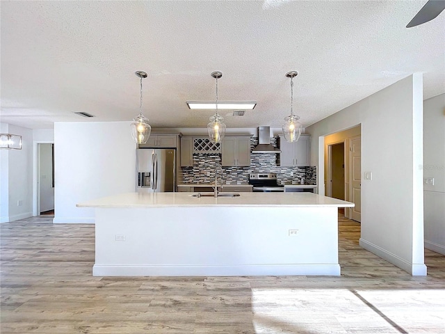 8600 Berkley Dr, Hudson, FL 34667 - kitchen featuring an island with sink, sink, gray cabinetry, stainless steel appliances, and wall chimney exhaust hood