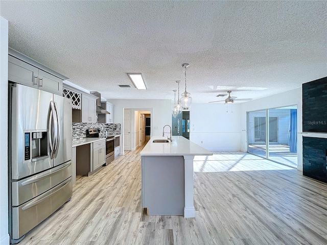 8600 Berkley Dr, Hudson, FL 34667 - kitchen with hanging light fixtures, an island with sink, appliances with stainless steel finishes, and gray cabinetry