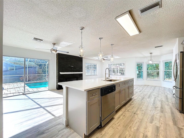 8600 Berkley Dr, Hudson, FL 34667 - kitchen featuring sink, gray cabinetry, a center island with sink, appliances with stainless steel finishes, and pendant lighting