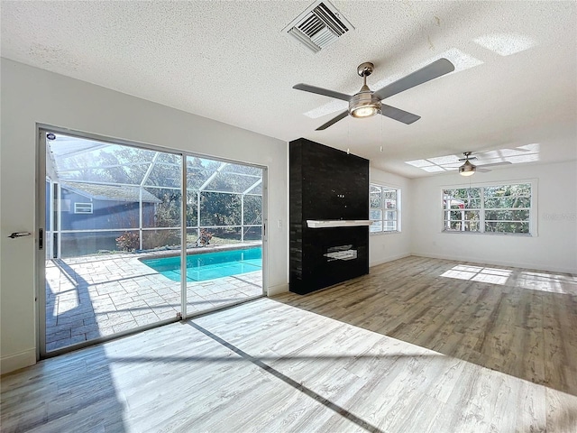 8600 Berkley Dr, Hudson, FL 34667 - unfurnished living room featuring hardwood / wood-style flooring, ceiling fan, and a textured ceiling