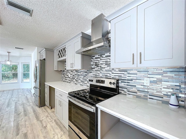 8600 Berkley Dr, Hudson, FL 34667 - kitchen with wall chimney exhaust hood, hanging light fixtures, light hardwood / wood-style flooring, stainless steel appliances, and decorative backsplash