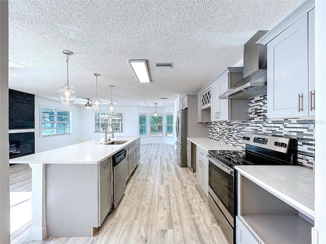 8600 Berkley Dr, Hudson, FL 34667 - kitchen with wall chimney exhaust hood, stainless steel appliances, sink, and gray cabinetry