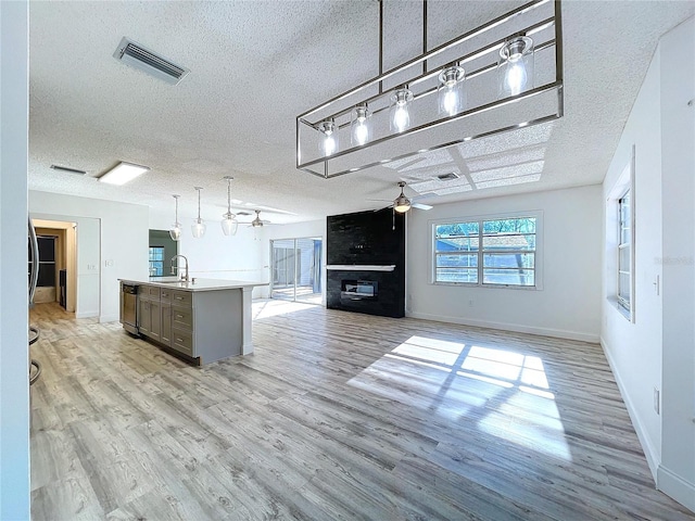 8600 Berkley Dr, Hudson, FL 34667 - kitchen featuring sink, decorative light fixtures, a center island with sink, light hardwood / wood-style flooring, and dishwasher
