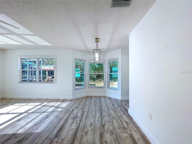 8600 Berkley Dr, Hudson, FL 34667 - unfurnished dining area featuring light hardwood / wood-style flooring and a textured ceiling