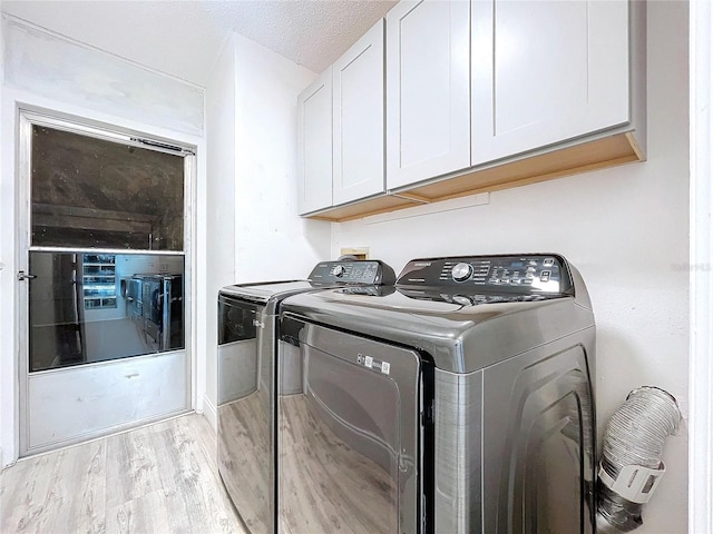 8600 Berkley Dr, Hudson, FL 34667 - washroom with cabinets, light hardwood / wood-style floors, washer and dryer, and a textured ceiling