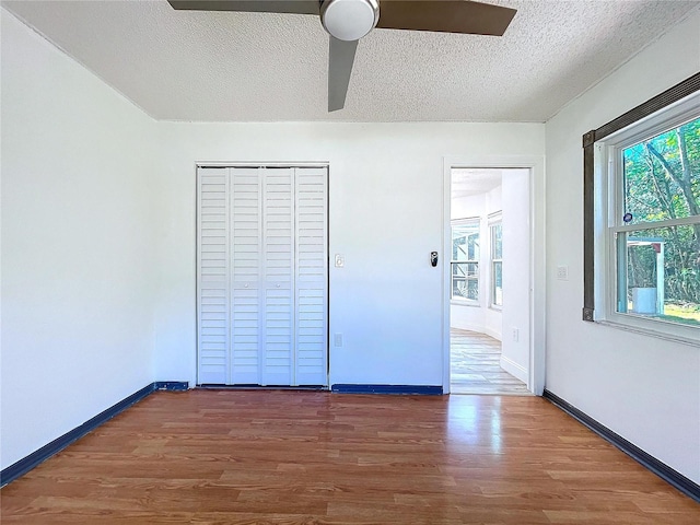 8600 Berkley Dr, Hudson, FL 34667 - unfurnished bedroom with ceiling fan, a closet, dark hardwood / wood-style flooring, and a textured ceiling