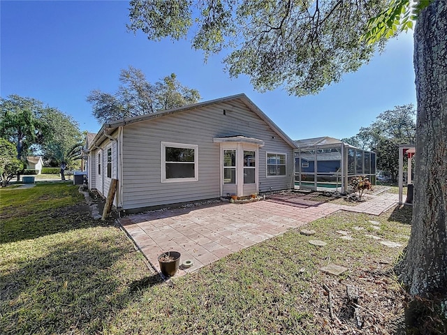 8600 Berkley Dr, Hudson, FL 34667 - back of house with a pool, a patio area, glass enclosure, and a lawn