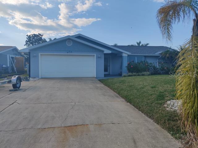 ranch-style home with a garage and a front lawn