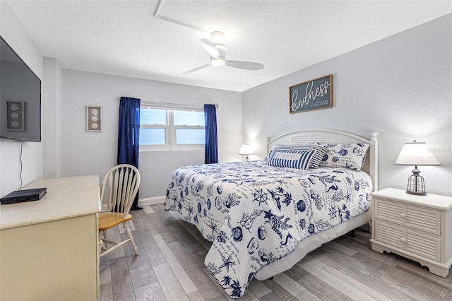 bedroom featuring hardwood / wood-style flooring, ceiling fan, and a textured ceiling