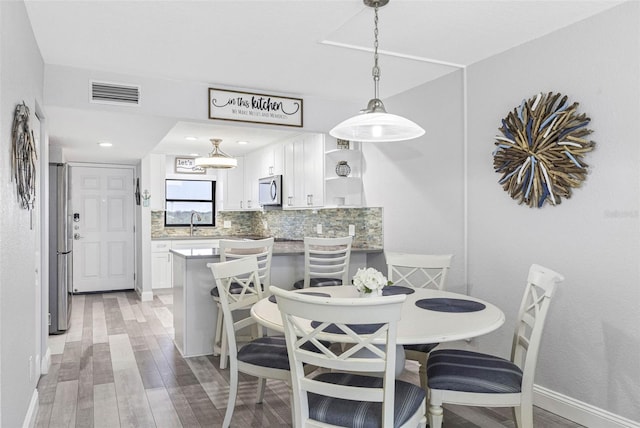 dining space featuring sink and light wood-type flooring