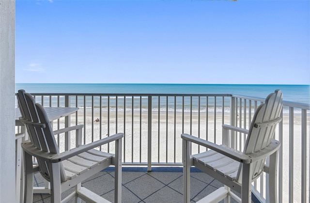 balcony featuring a water view and a beach view