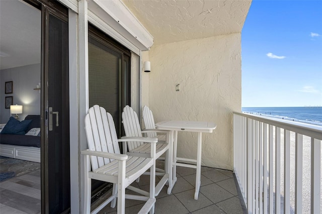 balcony with a water view and a beach view