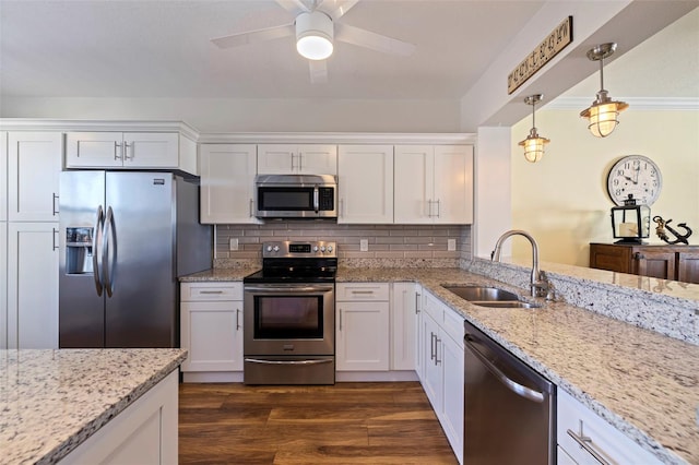 kitchen featuring white cabinets, dark wood finished floors, appliances with stainless steel finishes, pendant lighting, and a sink