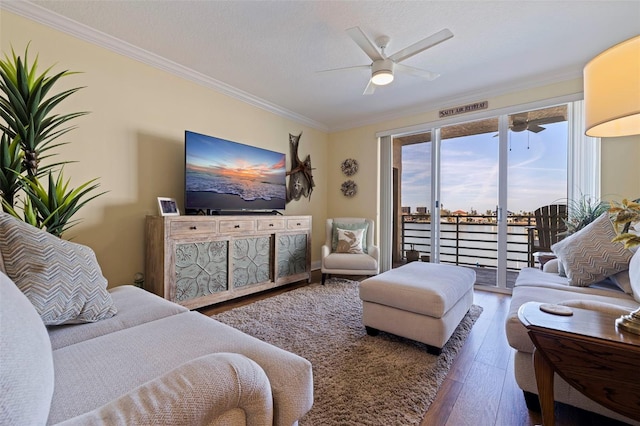 living area featuring ornamental molding, wood finished floors, and a ceiling fan