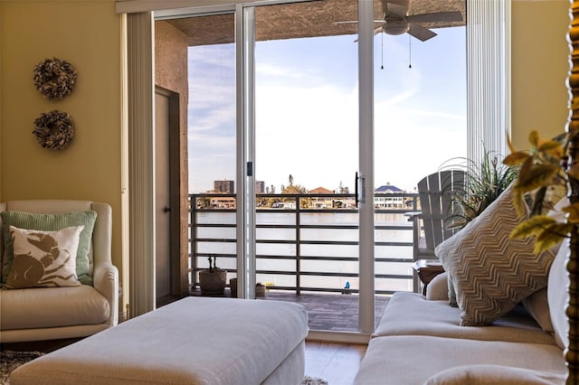 interior space featuring light wood-type flooring, a water view, and ceiling fan