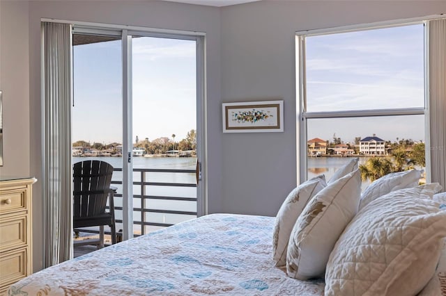 bedroom with access to exterior and a water view