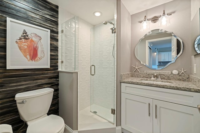 bathroom featuring toilet, a stall shower, and vanity