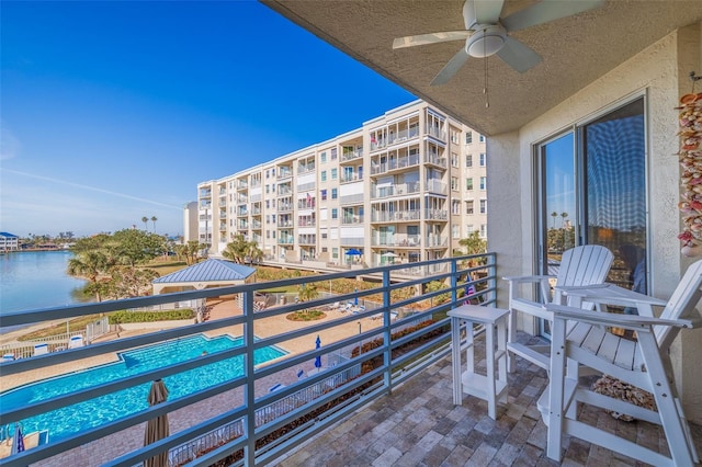 balcony with a water view and a ceiling fan