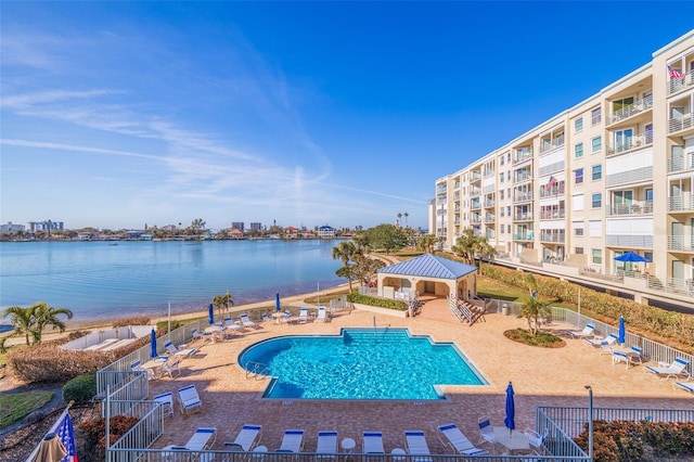 pool featuring a patio area, a water view, fence, and a gazebo