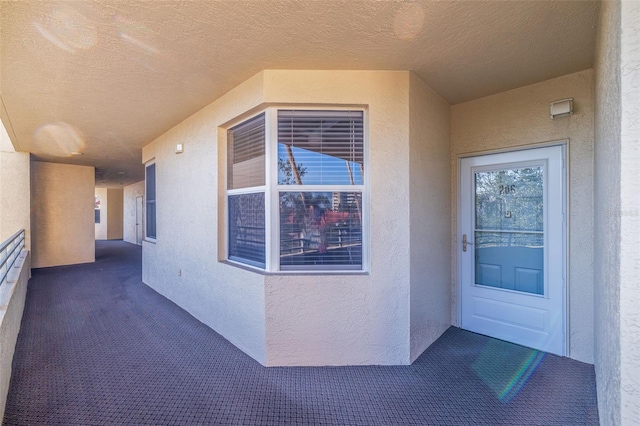 entrance to property with a balcony and stucco siding