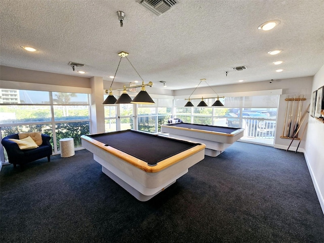 playroom featuring dark carpet, visible vents, and a healthy amount of sunlight