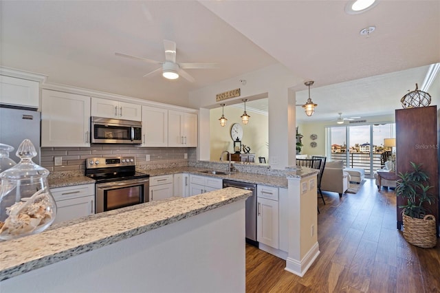 kitchen with ceiling fan, appliances with stainless steel finishes, a sink, white cabinets, and a peninsula
