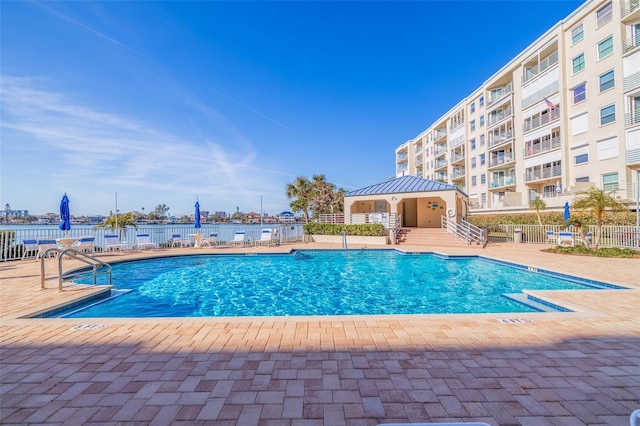 community pool with fence and a patio