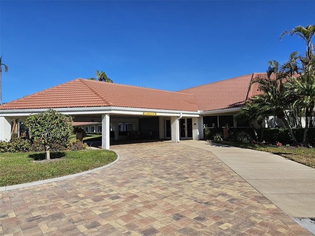 single story home featuring decorative driveway and a tiled roof