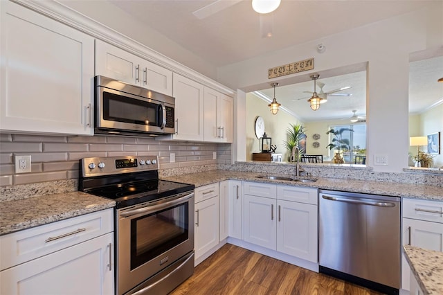 7902 Sailboat Key Blvd S Unit 206, South Pasadena, FL 33707 - kitchen featuring appliances with stainless steel finishes, a ceiling fan, a sink, white cabinets, and ornamental molding
