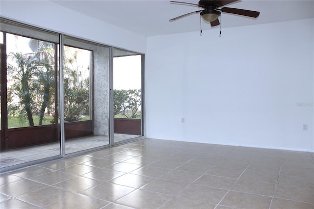 tiled empty room featuring ceiling fan