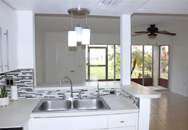 kitchen with sink, pendant lighting, and white cabinets