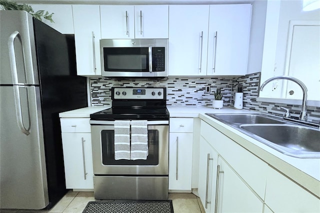 kitchen featuring stainless steel appliances, sink, white cabinets, and decorative backsplash