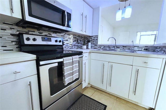 kitchen featuring pendant lighting, sink, appliances with stainless steel finishes, white cabinetry, and decorative backsplash