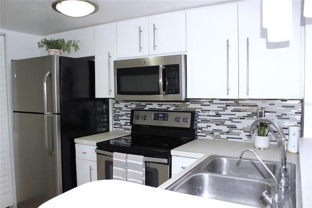 kitchen featuring appliances with stainless steel finishes, sink, white cabinets, and decorative backsplash