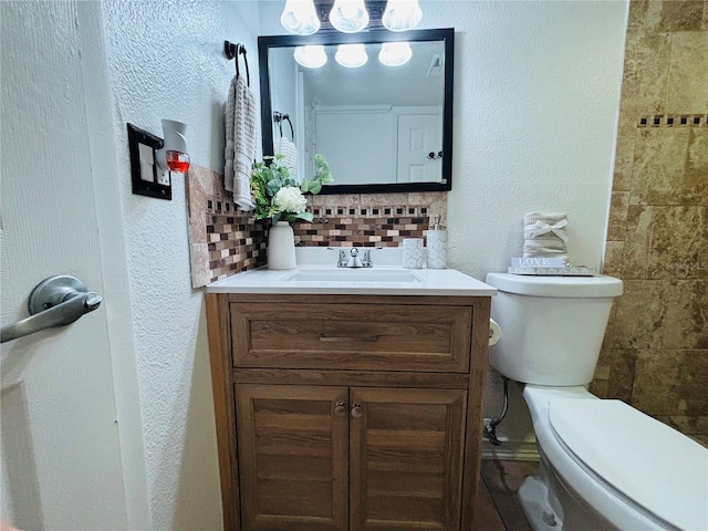 bathroom with vanity, backsplash, and toilet